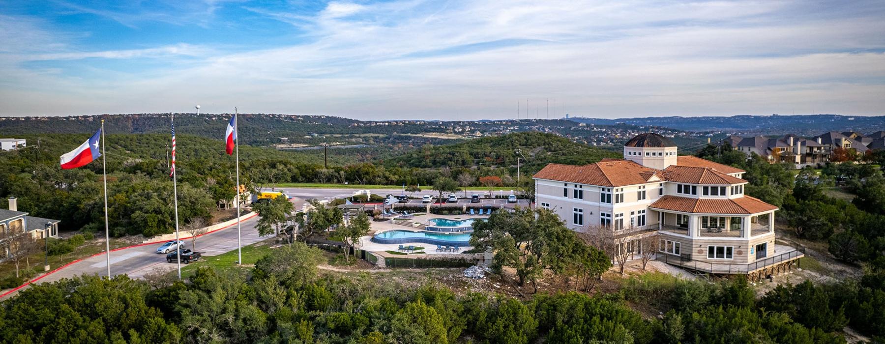 a building with a pool and trees around it